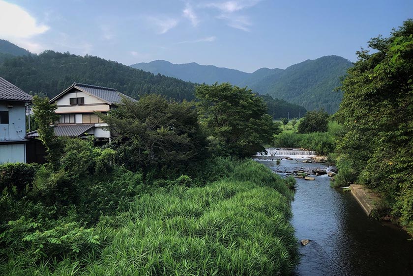 Des maisons bordent une rivière dans les collines d'Oharanomuracho.