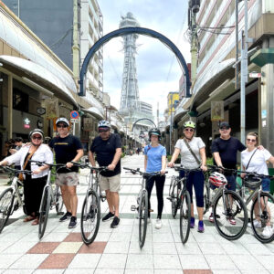 Cyclists posing in Shinsekai near Tsutenkaku with Cannondale Quick 3 Tour Bikes